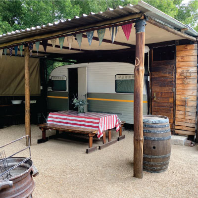 fixed caravan with a barbeque area and picnic bench